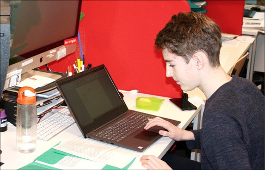 Junge schreibt auf dem Laptop