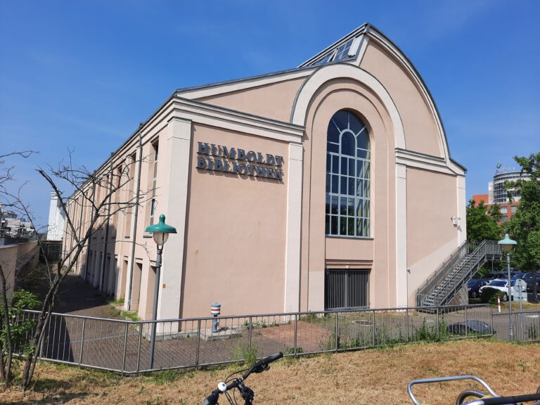 Ein beiges Gebäude vor blauem Himmel.