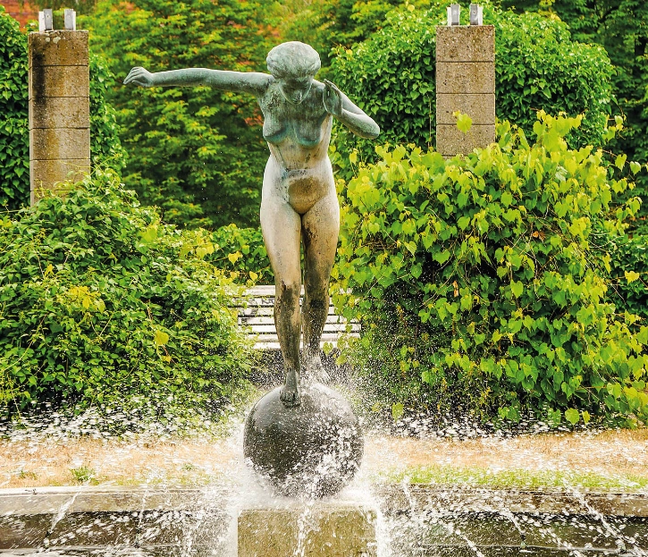 Der Springbrunnen "Kugelläuferin" zeigt eine Bronze-Statue auf einer Kugel, um die herum Wasser sprudelt.