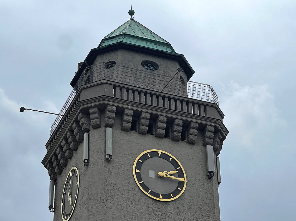 Eine Kirchturmspitze mit einer goldenen Uhr