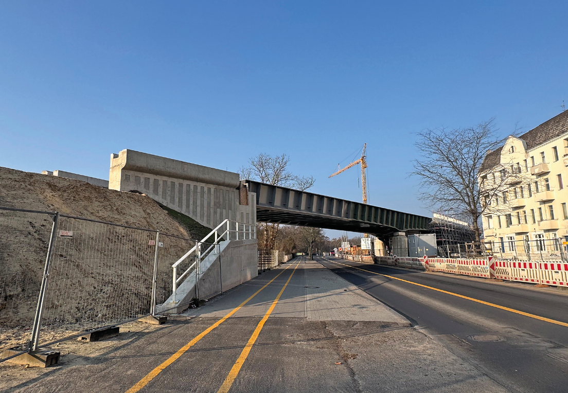 Eien Brücke führt über eine Straße, dahinter blauer Himmel.