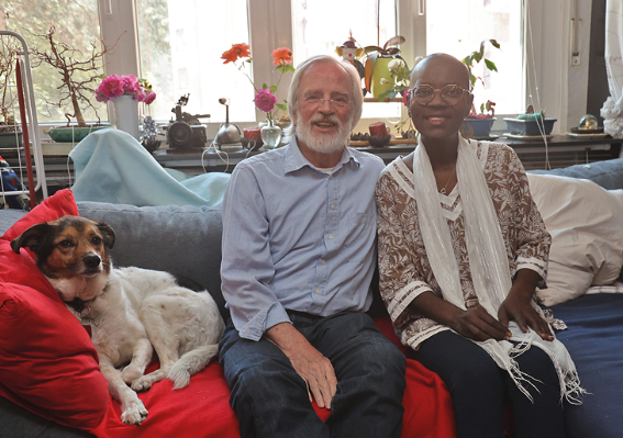Ein Mann, eine Frau und ein Hund auf einem Sofa