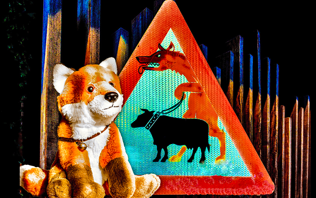 Ein Stofftier Fuchs sitz neben einem Warnschild