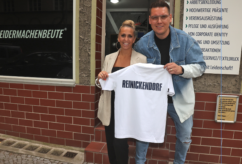 ein mann und eine frau zeigen ein t-shirt