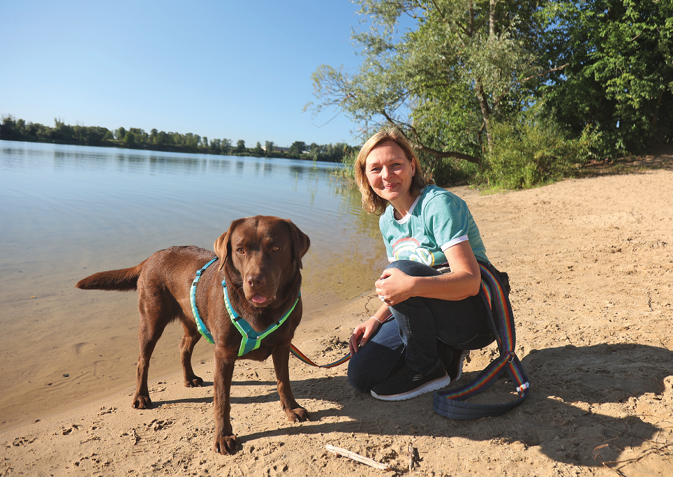 Eine Frau mit Hund an einem See