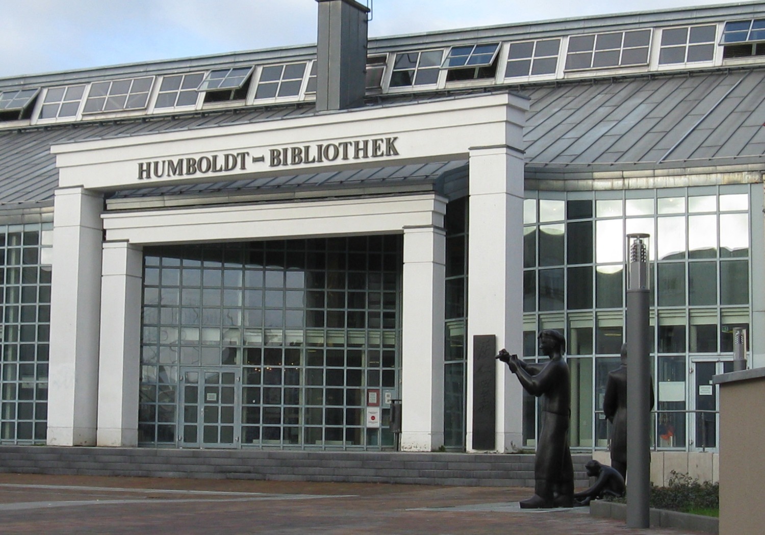 Die Fassade der Humboldt-Bibliothek in Berlin-Tegel mit dem großen Eingangsportal im Vordergrund