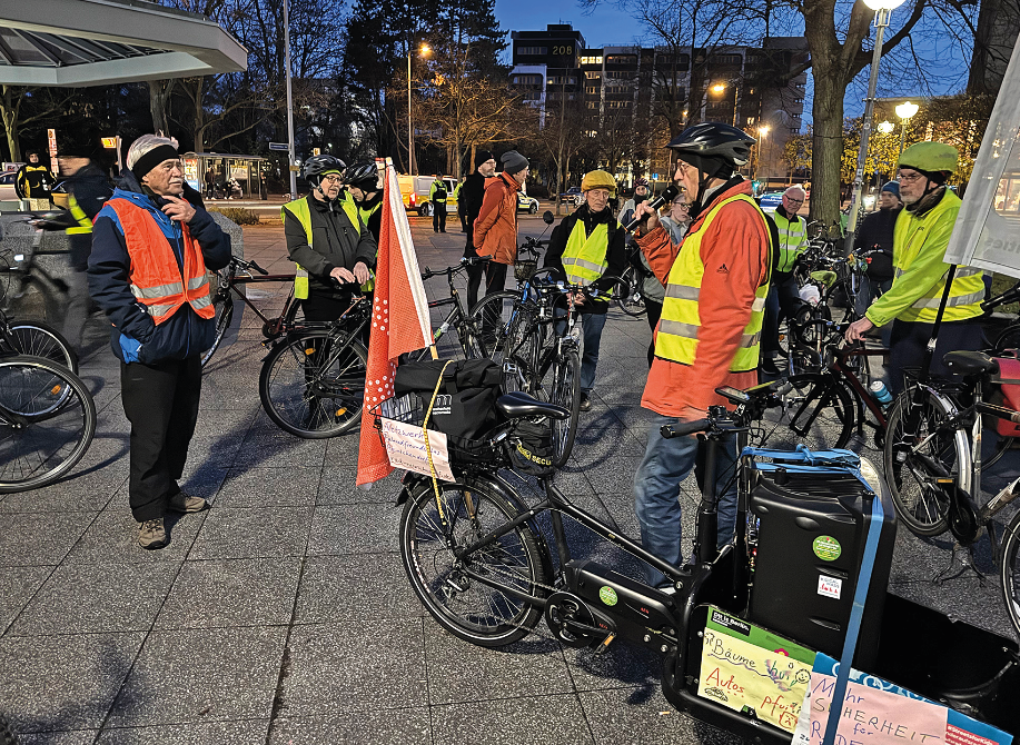 Menschen mit Fahrrädern und Fahnen im Dunkeln bereiten sich auf die Demo vor