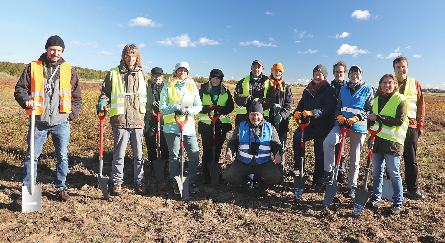 Eine Gruppe Menschen mit Warnwesten und Schaufeln