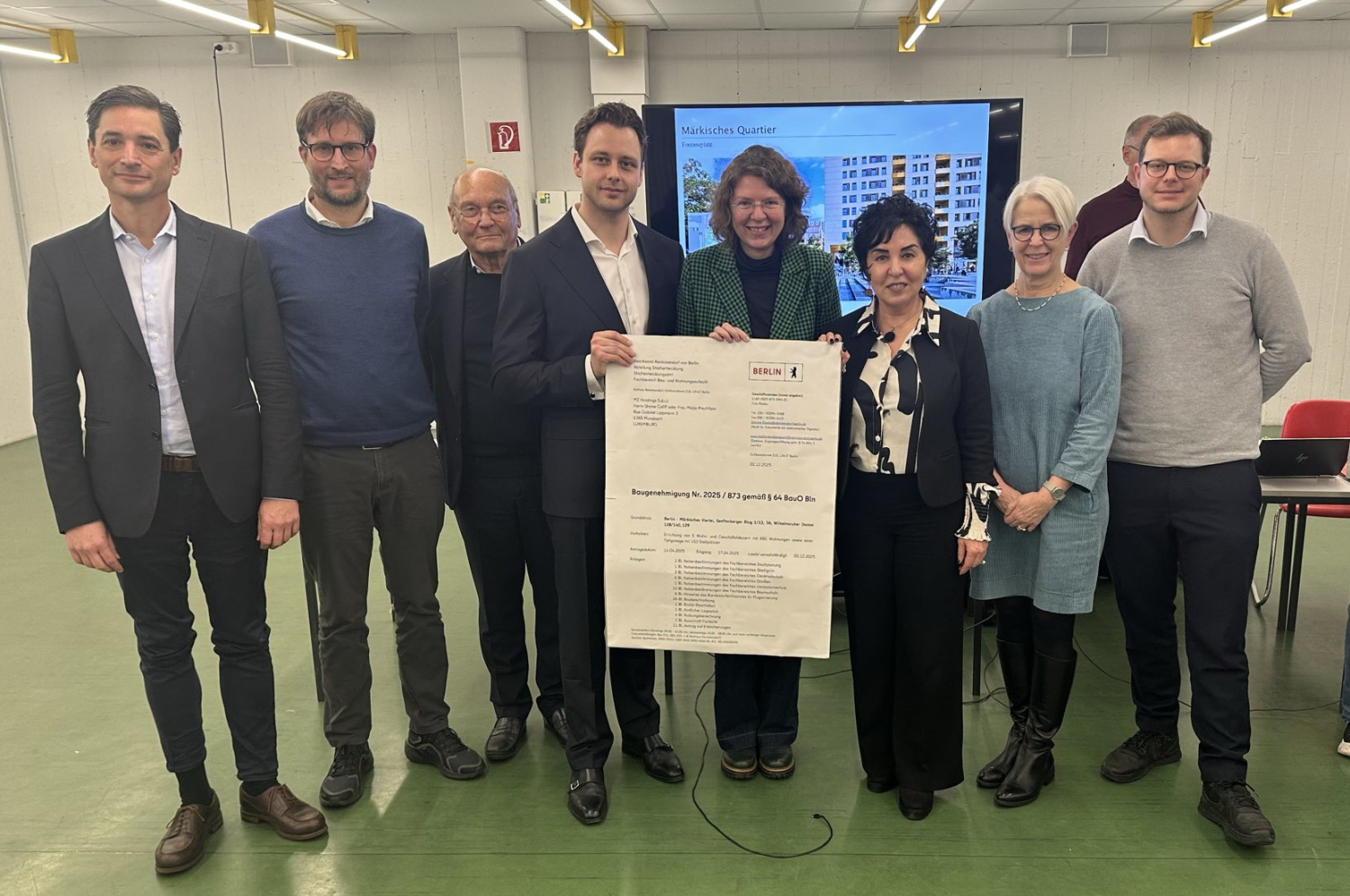 Eine Gruppe Menschen mit einem großen Plakat in ihrer Mitte.