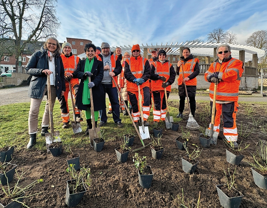 Eine Gruppe mit Warnwesten vor Stecklingen