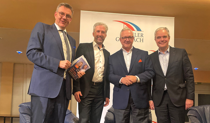 Vier Männer vor einer Leinwand