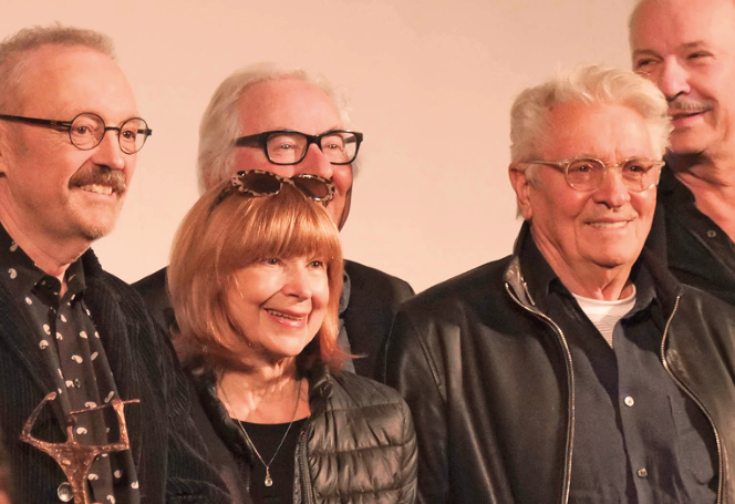 Eine Frau und vier Männer lächeln