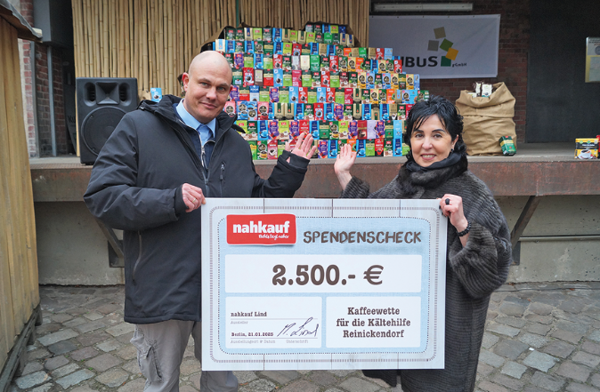 Ein Mann und eine Frau halten einen Scheck hoch