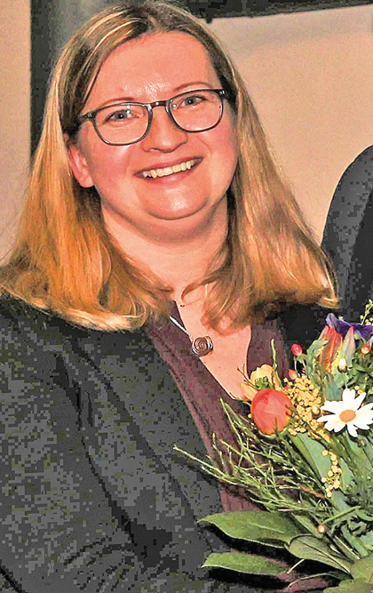 Eine Frau mit einem Blumenstrauß lächelt