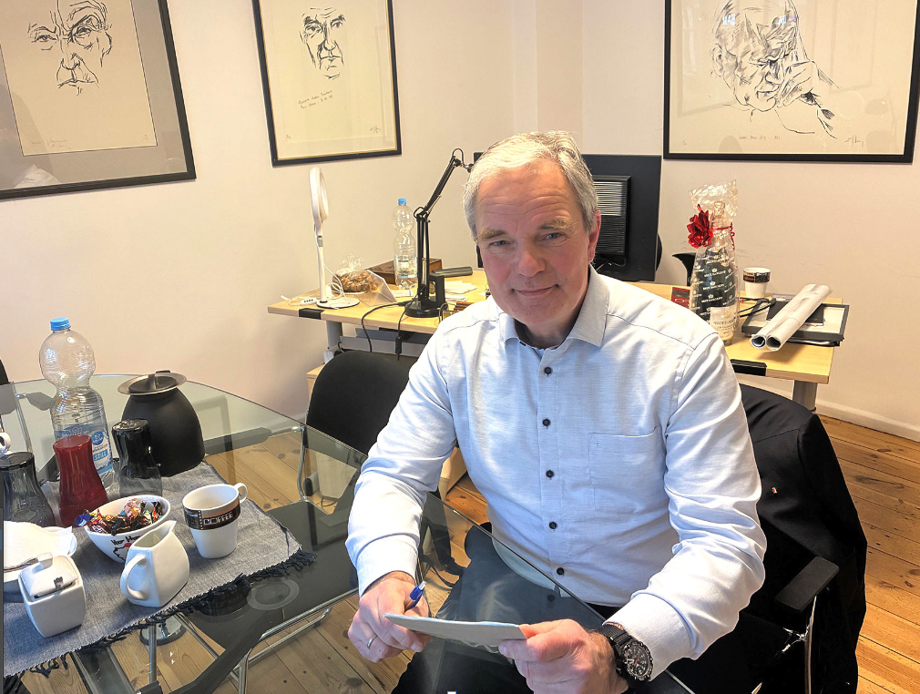 EIn Mann sitzt in einem Büro am Schreibtisch