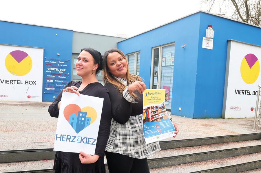 zwei Frauen halten Plakate und Flyer hoch