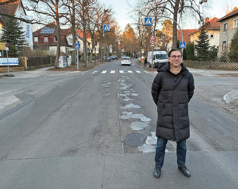 Ein Mann steht auf einer stark beschädigten Straße