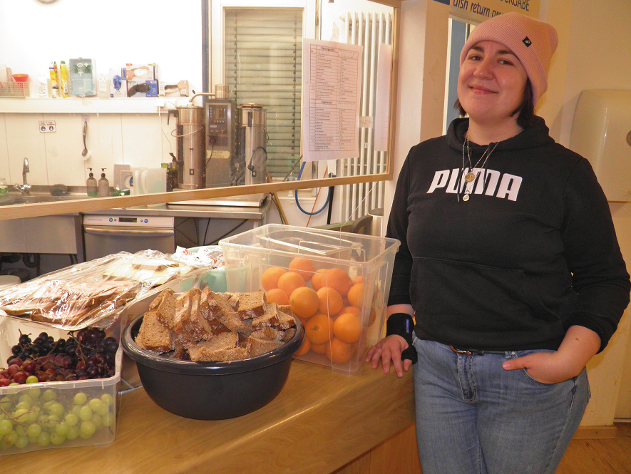 Eine junge Frau lehnt an einem Essenstresen