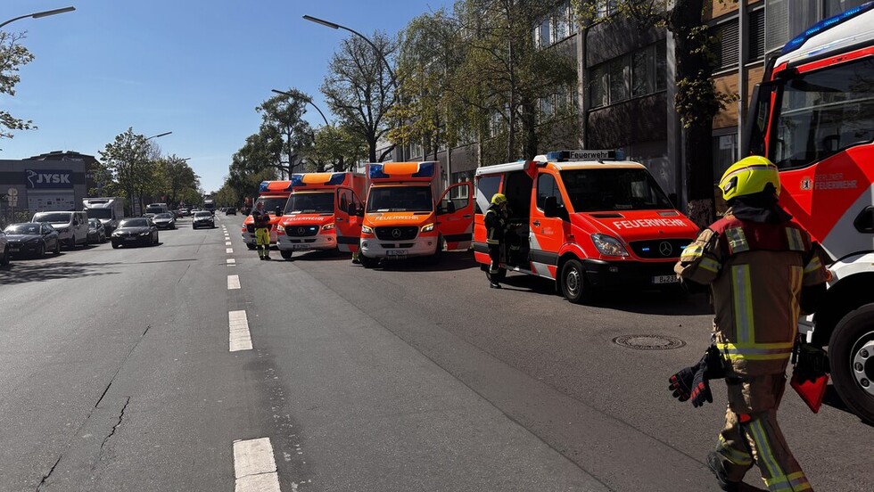 Mehrere Rettungsfahrzeuge stehen hintereinander am Rand einer breiten Straße.