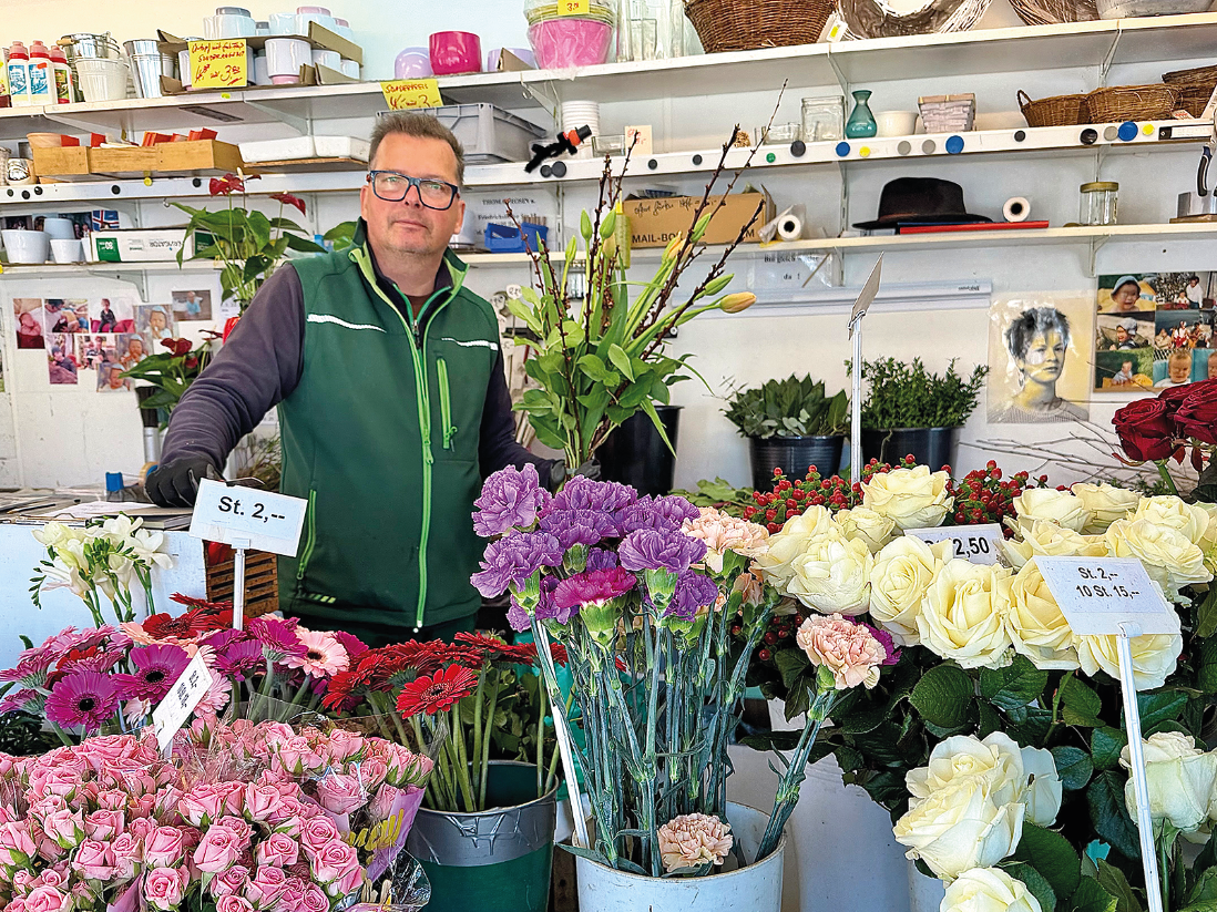 Ein Mann steht inmitten von Schnittblumen