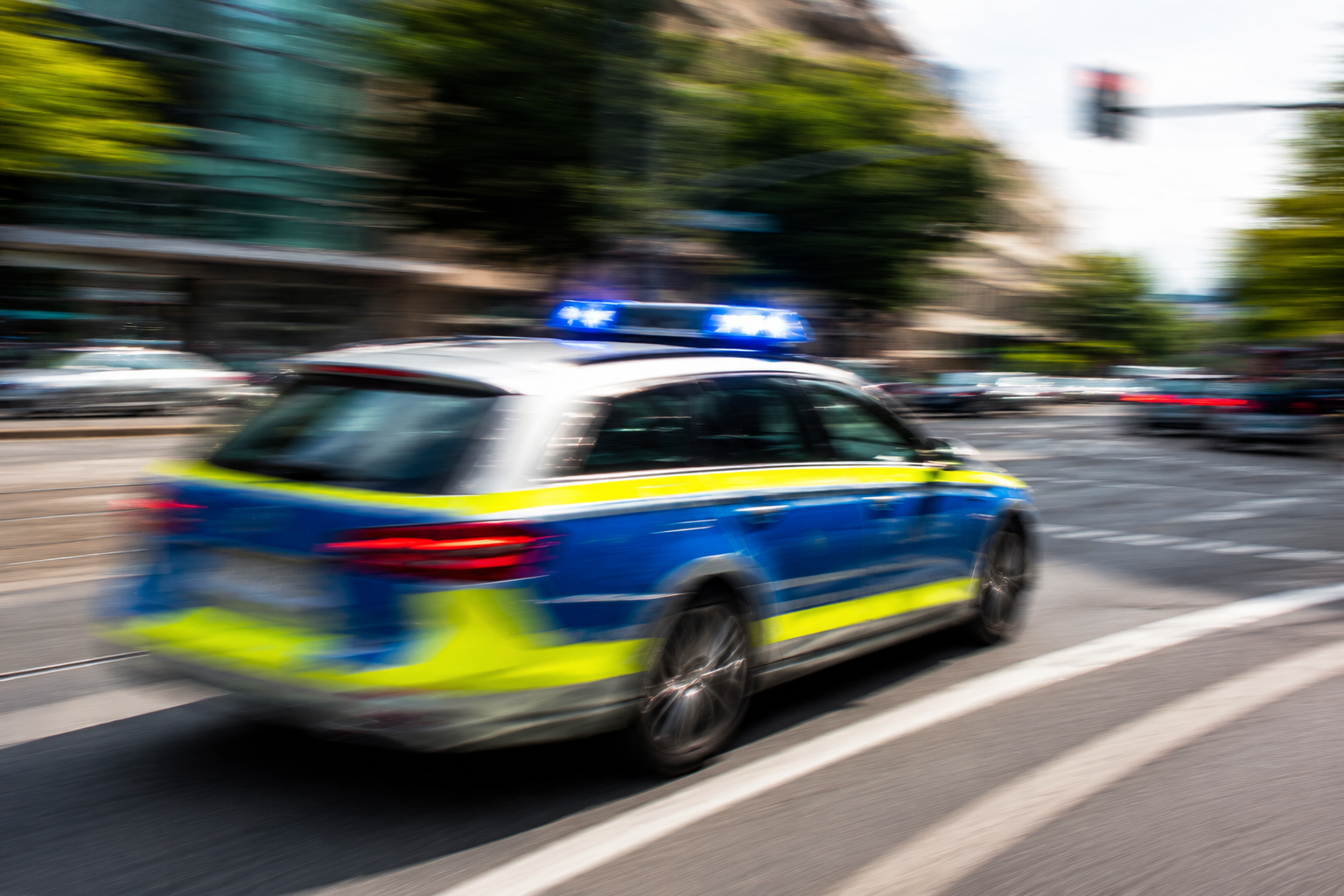 Ein Polizeiauto fährt durch eine Straße.