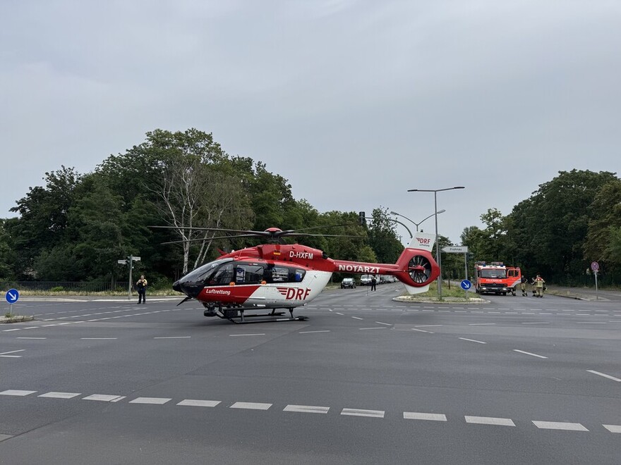 Das Bild zeigt einen auf einer Straßenkreuzung gelandeten Rettungshubschrauber.