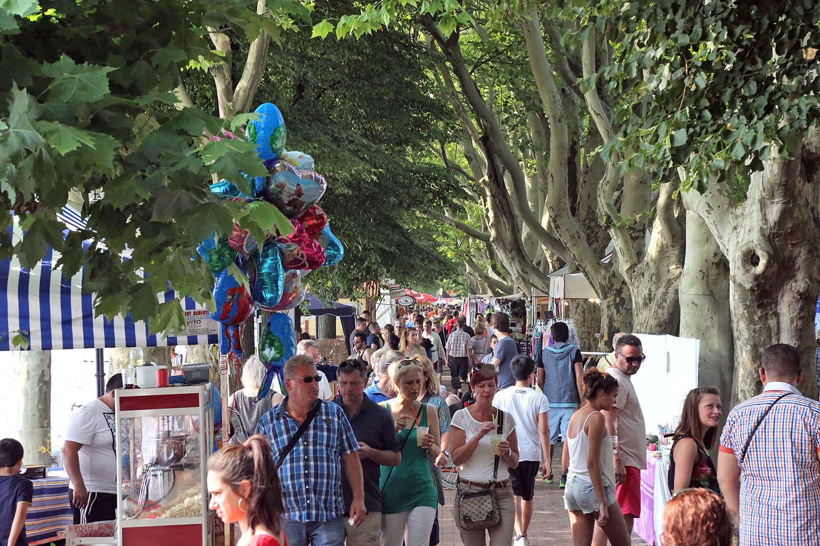 Viele Menschen auf einer Promenade mit Ständen