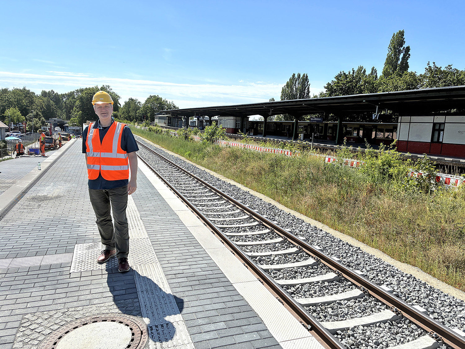 Ein Mann mit Warnweste auf einem Bahnhof