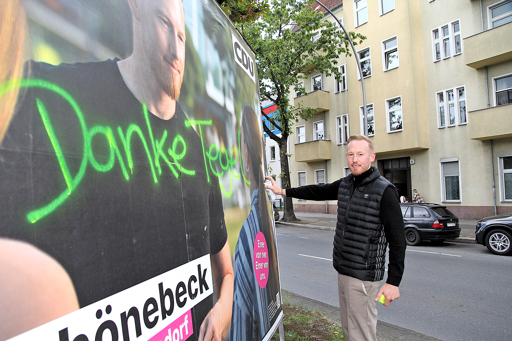 Ein Mann schreibt auf ein Wahlplakat
