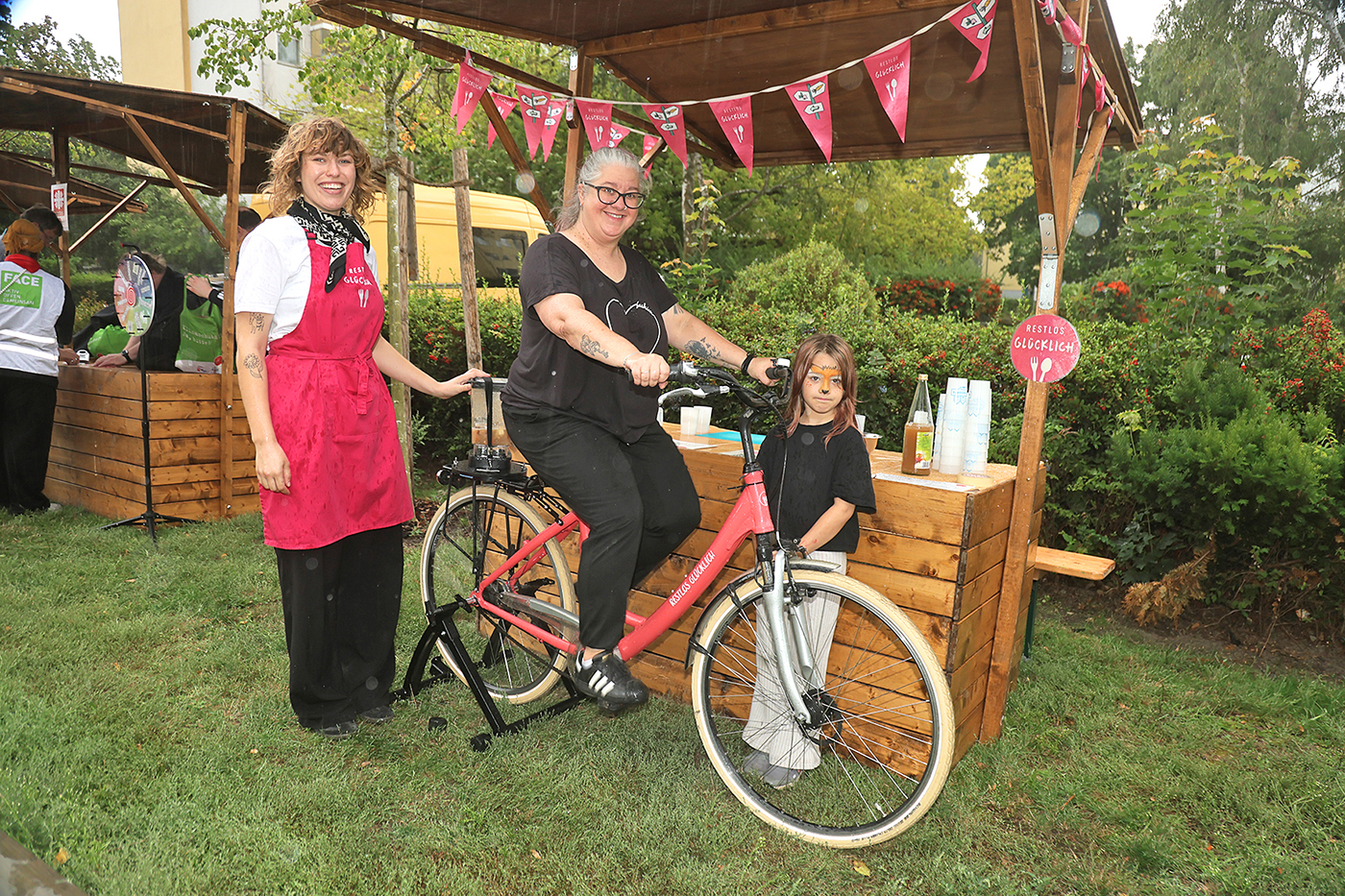 Eine Frau auf einem Fahrrad vor einem Stand